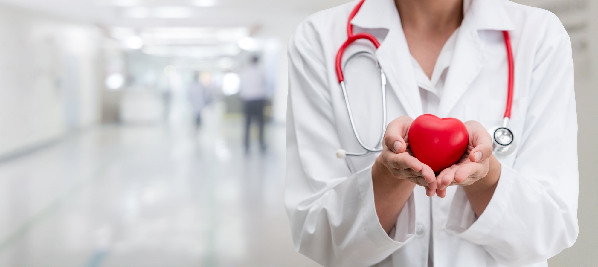Healthcare professional in a white coat holding a red heart, representing Hart's commitment to reliable and caring healthcare data integration.