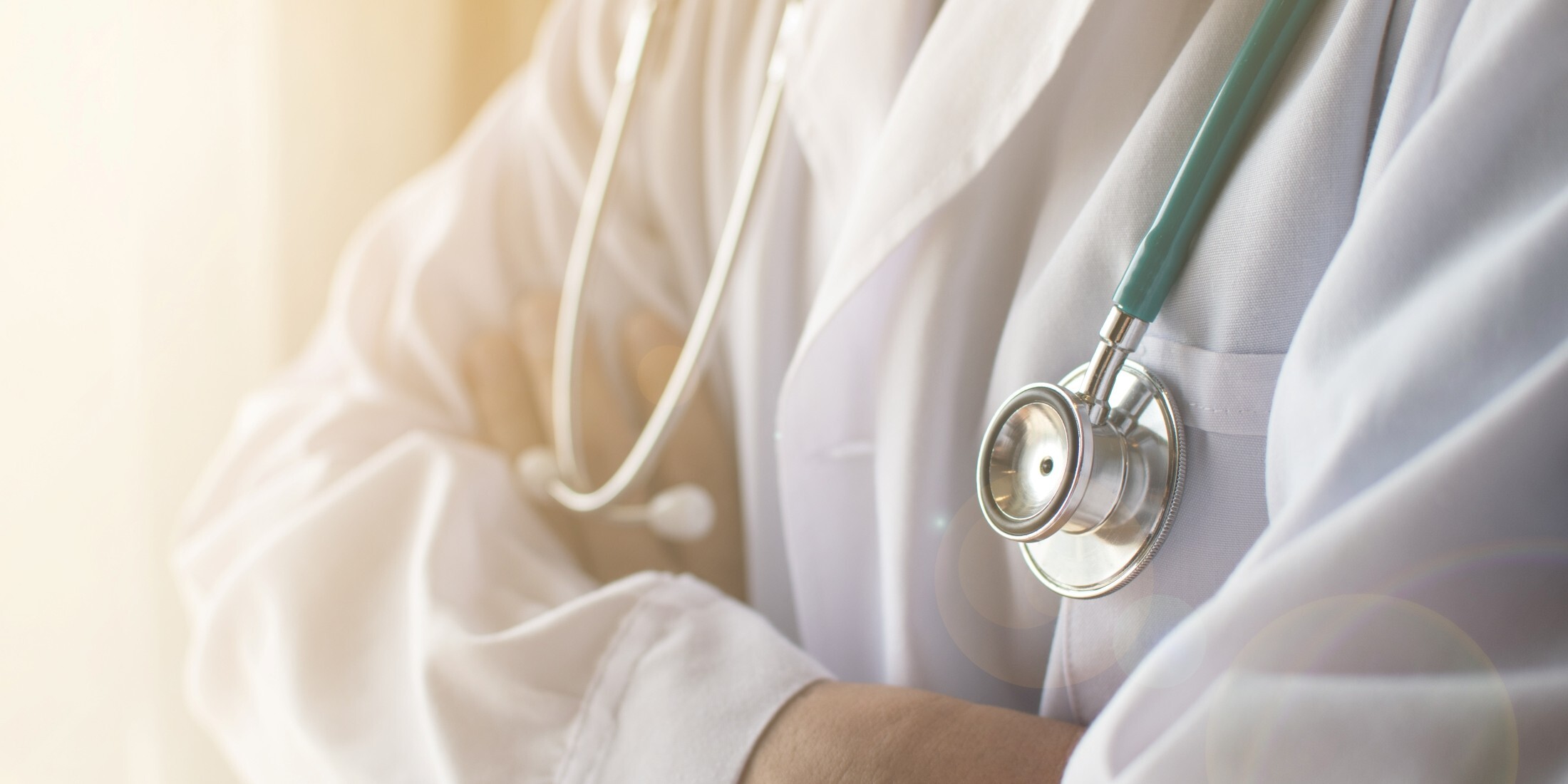 Healthcare professional in white coat with stethoscope, representing the high stakes of patient data protection.