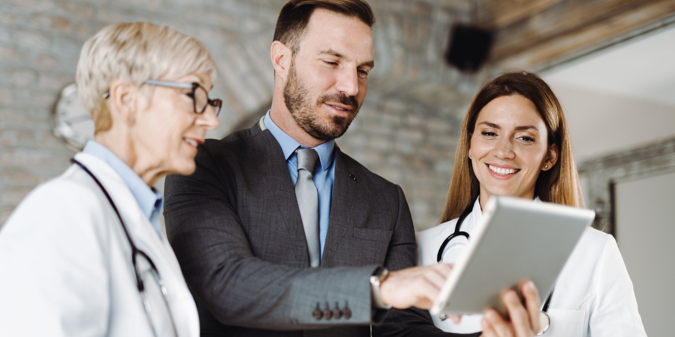 Young male and female professionals reviewing patient data for hospital-at-home care programs, with Hart’s solutions.